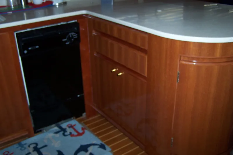 Slide: The Image of 2004 Novatec Islander CPMY kitchen with wood cabinets and nautical-themed rug. - 47