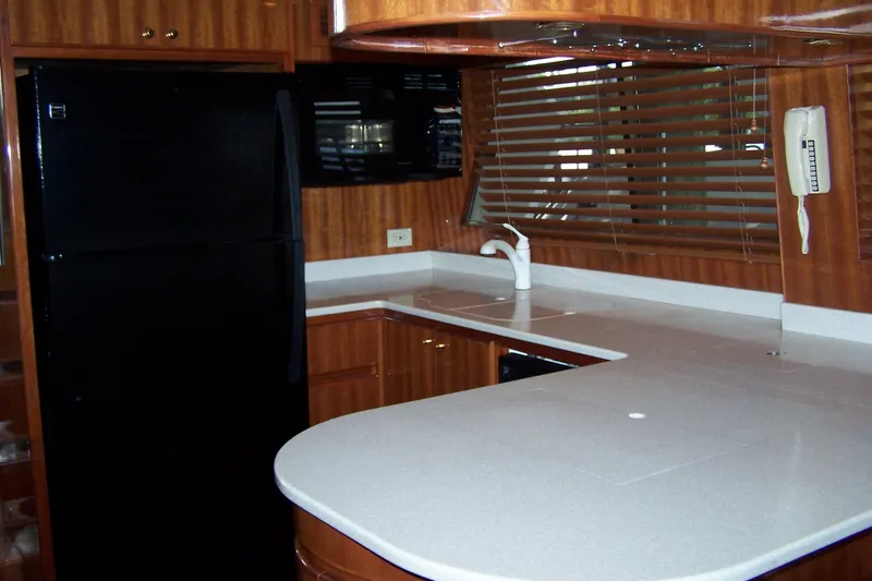 Slide: The Image of 2004 Novatec Islander CPMY yacht kitchen with modern appliances and wooden cabinetry. - 48
