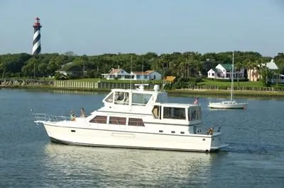 Slide: The Image of 2004 Novatec Islander CPMY yacht cruising near a lighthouse and coastal homes. - 6
