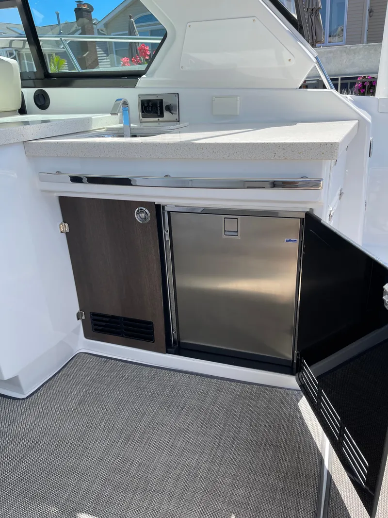 Slide: The Image of 2017 Monterey 360 Sport Coupe docked, featuring spacious deck and American flags. - 6