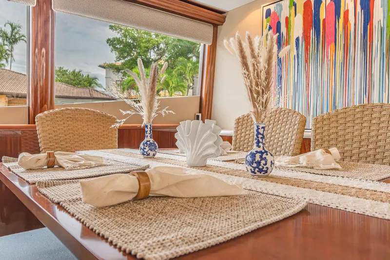 Slide: The Image of Elegant dining area on 2002 Lazzara 80 Skylounge yacht with artistic decor and woven chairs. - 18