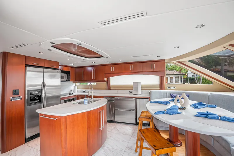 Slide: The Image of Luxurious kitchen and dining area in a 2002 Lazzara 80 Skylounge yacht, featuring modern appliances. - 19