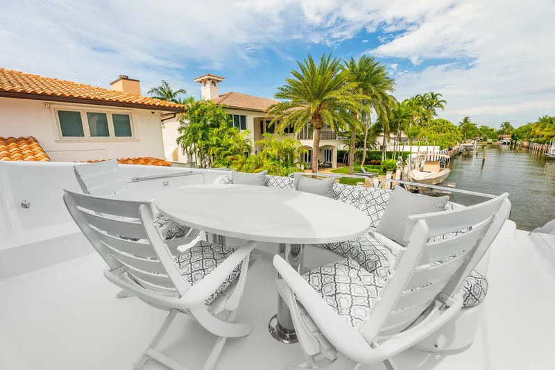 Slide: The Image of Luxury yacht deck with white seating, table, and waterfront view; Lazzara 80 Skylounge, 2002. - 31