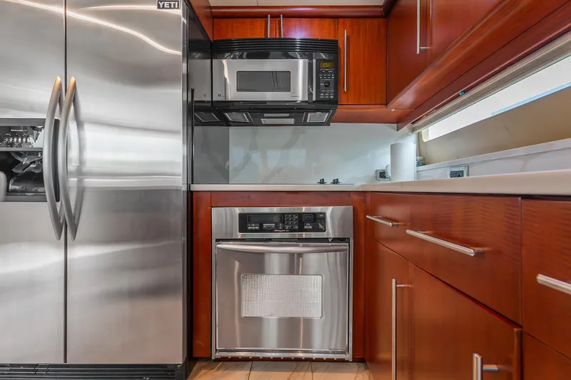 Slide: The Image of Modern kitchen in 2002 Lazzara 80 Skylounge yacht with stainless steel appliances and wooden cabinetry. - 53