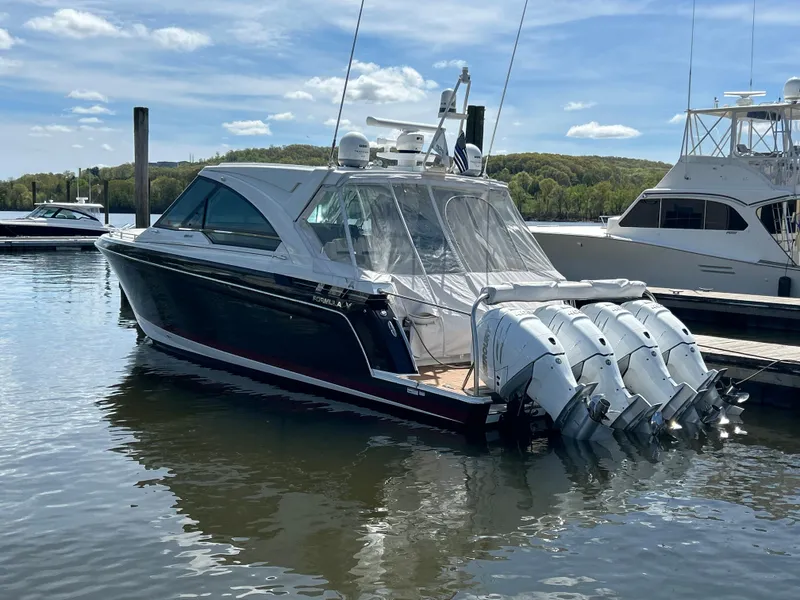 The Image of 2022 Formula 400 Super Sport Crossover boat docked with four outboard engines. - 0