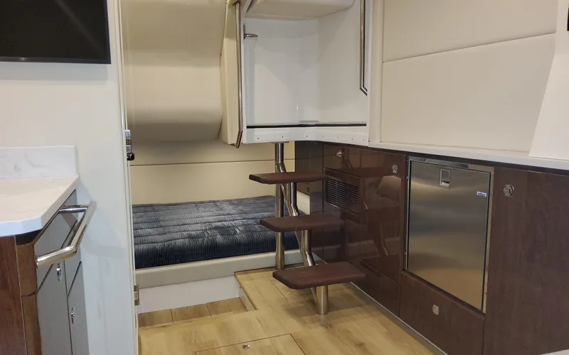 Slide: The Image of 2022 Formula 400 Super Sport Crossover interior with bed, stairs, and kitchenette. - 13