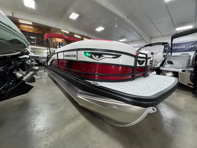 Slide: The Image of 2025 Bennington 24 ML pontoon boat displayed in a showroom, featuring sleek design and modern amenities. - 1