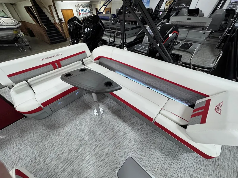 Slide: The Image of 2025 Bennington 24 ML boat interior with white and red seating and a central table. - 10