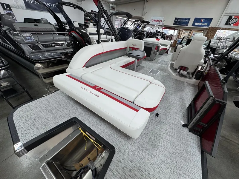 Slide: The Image of 2025 Bennington 24 ML pontoon boat interior with white and red seating in showroom. - 13