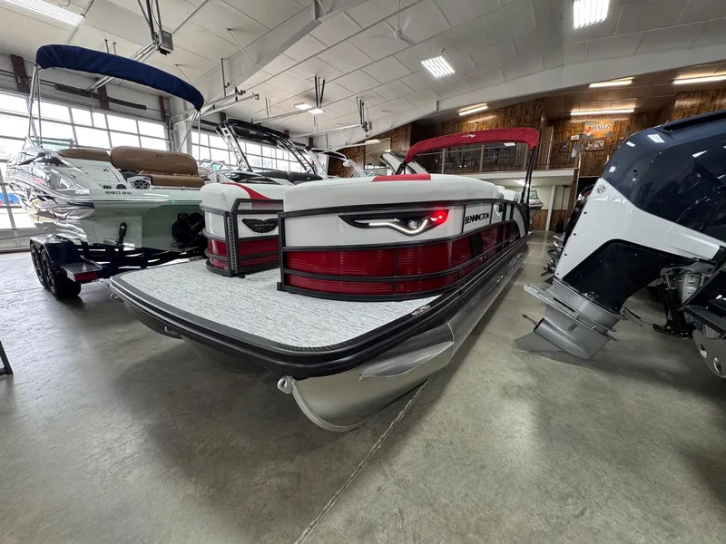 Slide: The Image of 2025 Bennington 24 ML pontoon boat displayed in a showroom with other boats. - 3