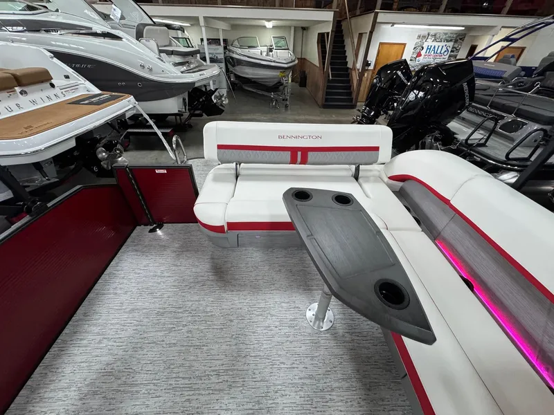 Slide: The Image of 2025 Bennington 24 ML boat interior with seating and table, displayed in a showroom. - 7