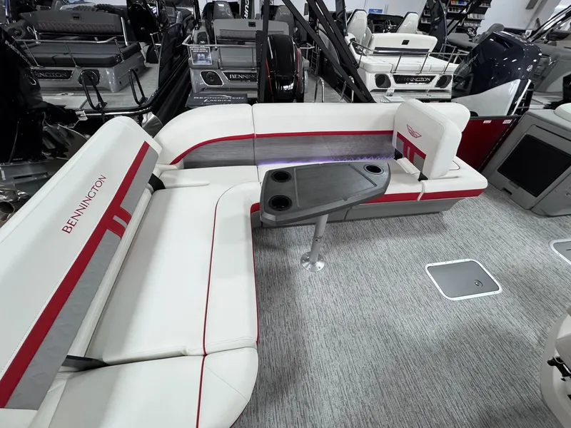 Slide: The Image of 2025 Bennington 24 ML boat interior with white and red seating, table, and modern design. - 9