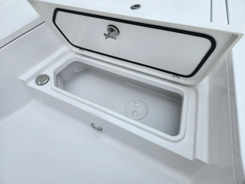 Slide: The Image of 2025 Sportsman Masters 247 Bay Boat storage compartment, open lid, white interior. - 11