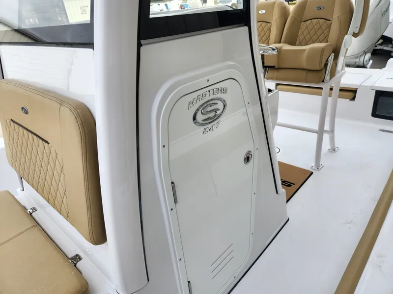 Slide: The Image of 2025 Sportsman Masters 247 Bay Boat interior with tan seating and console. - 16