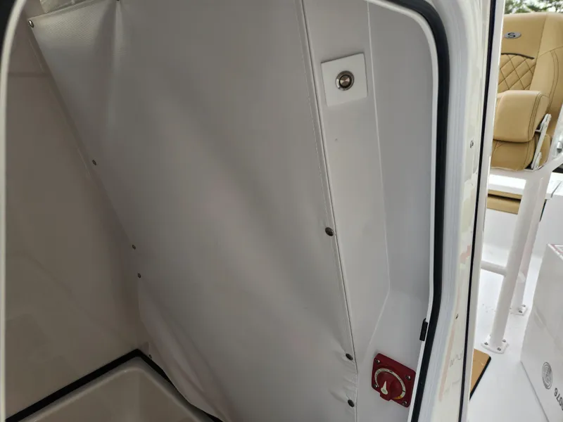 Slide: The Image of 2025 Sportsman Masters 247 Bay Boat interior, featuring white paneling and beige seating. - 18