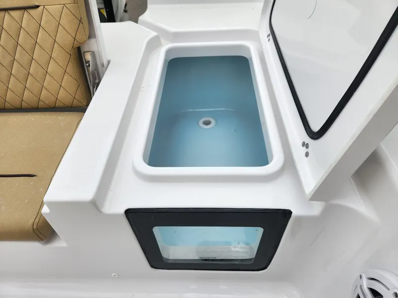 Slide: The Image of 2025 Sportsman Masters 247 Bay Boat livewell with open lid and cushioned seating. - 26