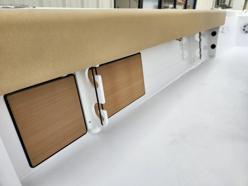 Slide: The Image of 2025 Sportsman Masters 247 Bay Boat interior with tan seating and storage compartments. - 27