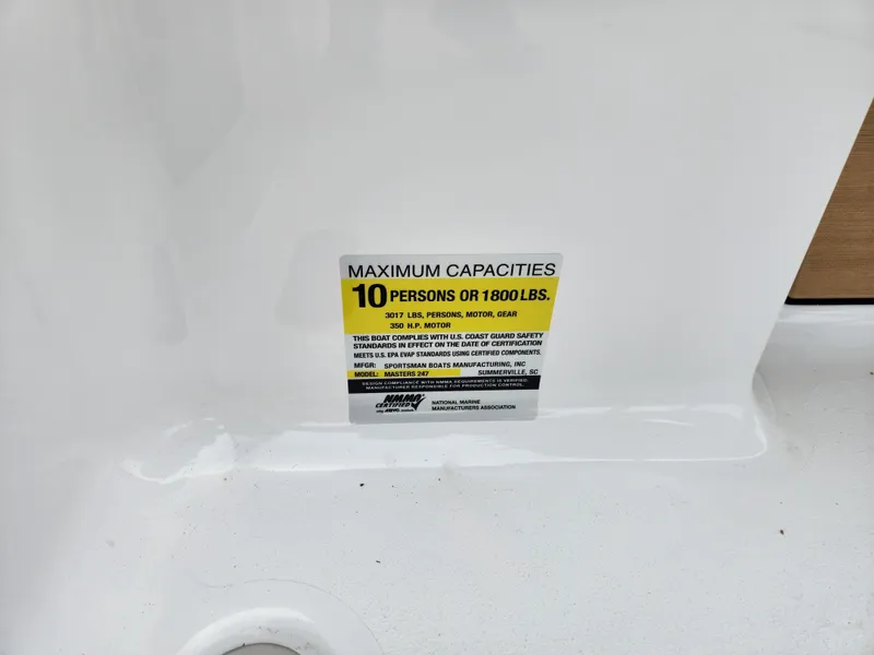 Slide: The Image of 2025 Sportsman Masters 247 Bay Boat capacity label, maximum 10 persons or 1800 lbs. - 30