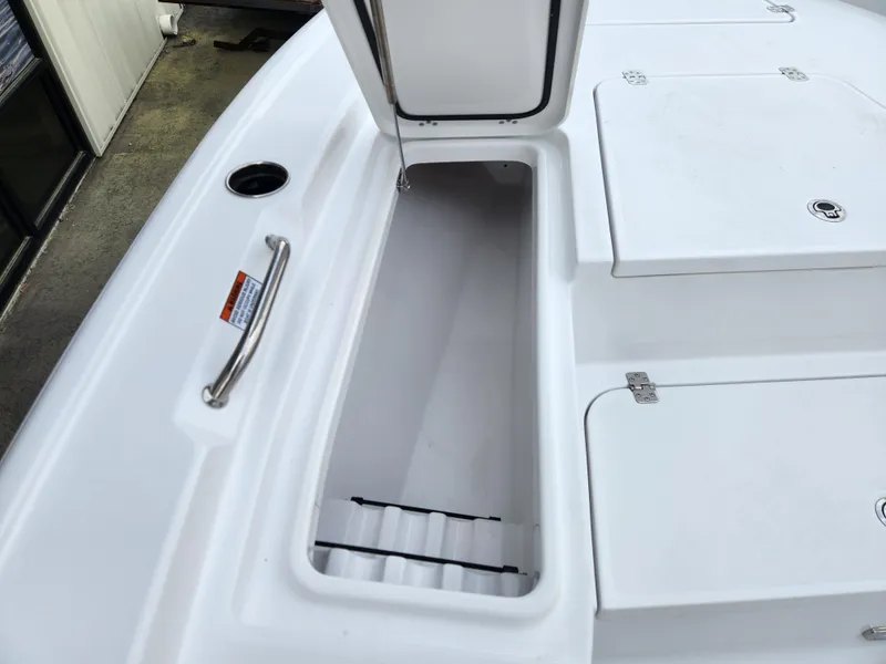 Slide: The Image of 2025 Sportsman Masters 247 Bay Boat storage compartment with open hatch and stainless steel handle. - 8