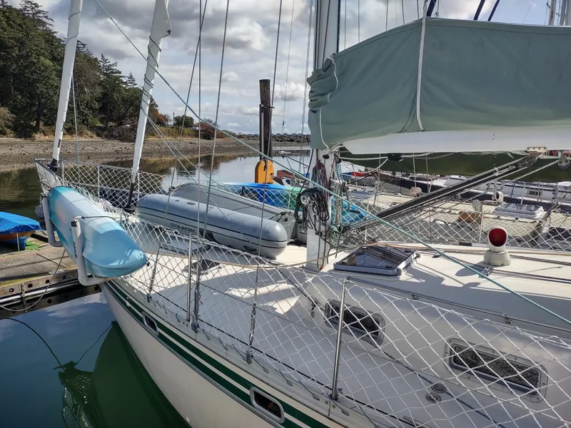 Slide: The Image of 1988 Cascade 42 sailboat docked, featuring a blue kayak and inflatable dinghy on deck. - 14