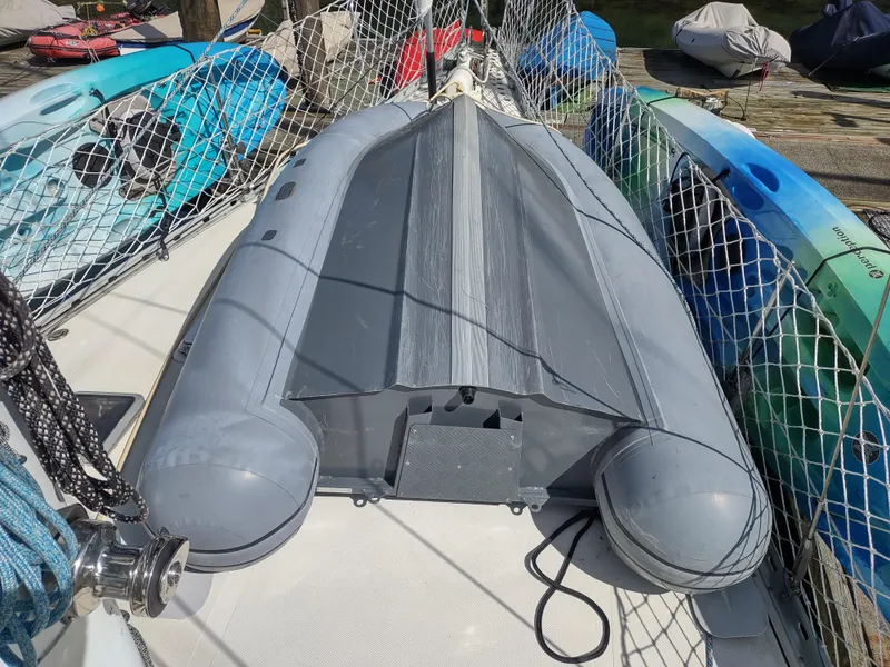 Slide: The Image of Inflatable boat on Cascade 42 sailboat deck, 1988 model, surrounded by kayaks. - 16
