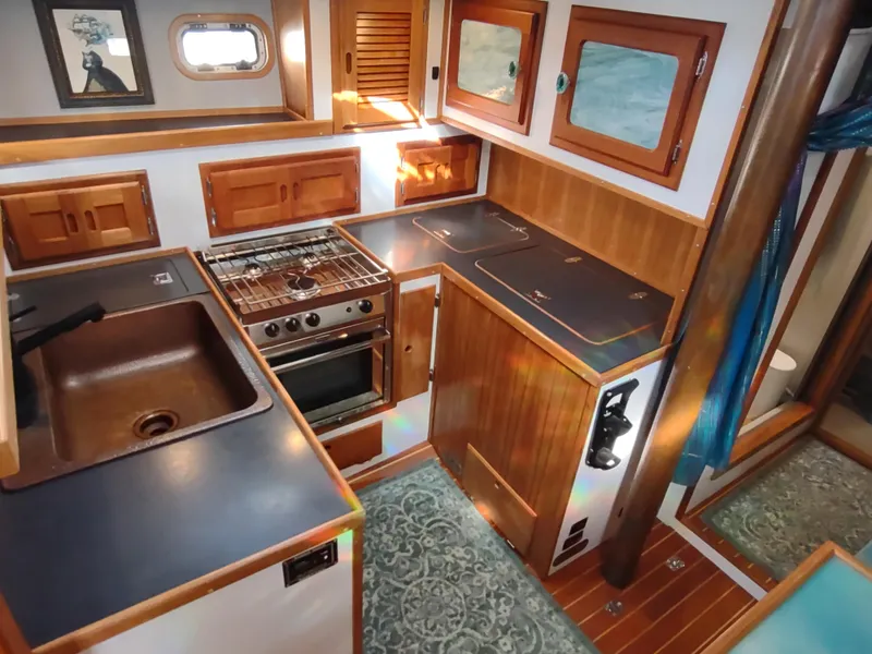 Slide: The Image of 1988 Cascade 42 yacht kitchen with wooden cabinetry, stove, and sink. - 45