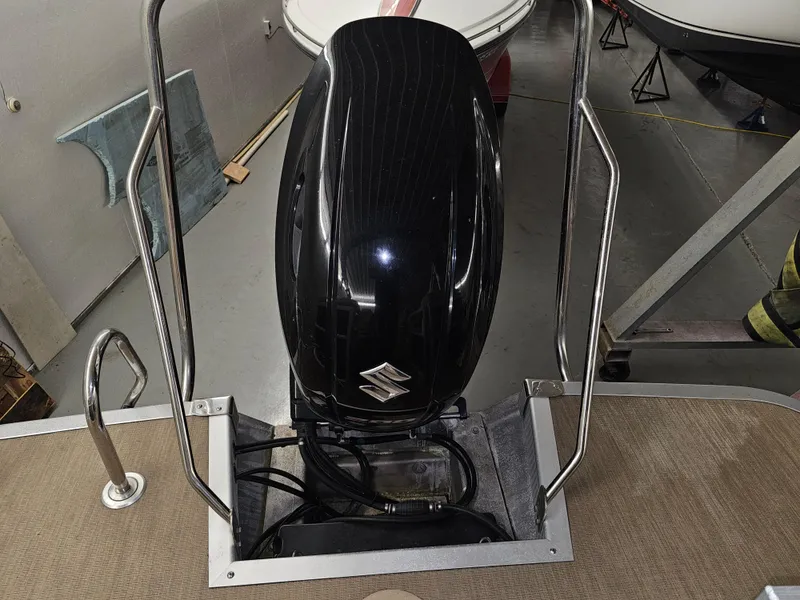 Slide: The Image of 2018 Bennington SX25 boat with Suzuki outboard motor in a garage. - 15