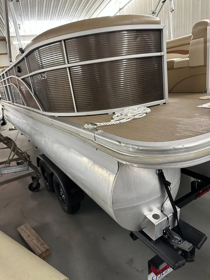 Slide: The Image of 2018 Bennington SX25 pontoon boat in a storage facility, showcasing sleek design and spacious deck. - 16