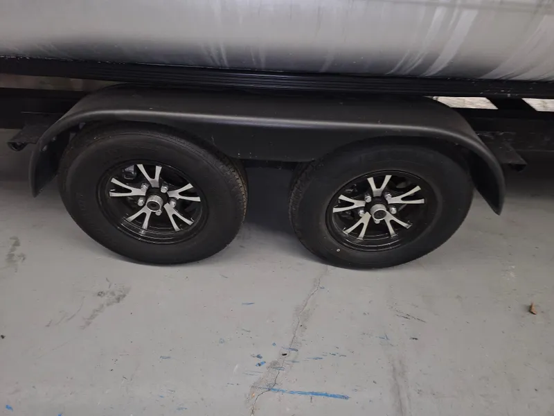 Slide: The Image of Trailer wheels of a 2018 Bennington SX25 boat, parked indoors. - 19