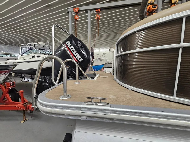 Slide: The Image of 2018 Bennington SX25 boat with Suzuki outboard motor in storage facility. - 3