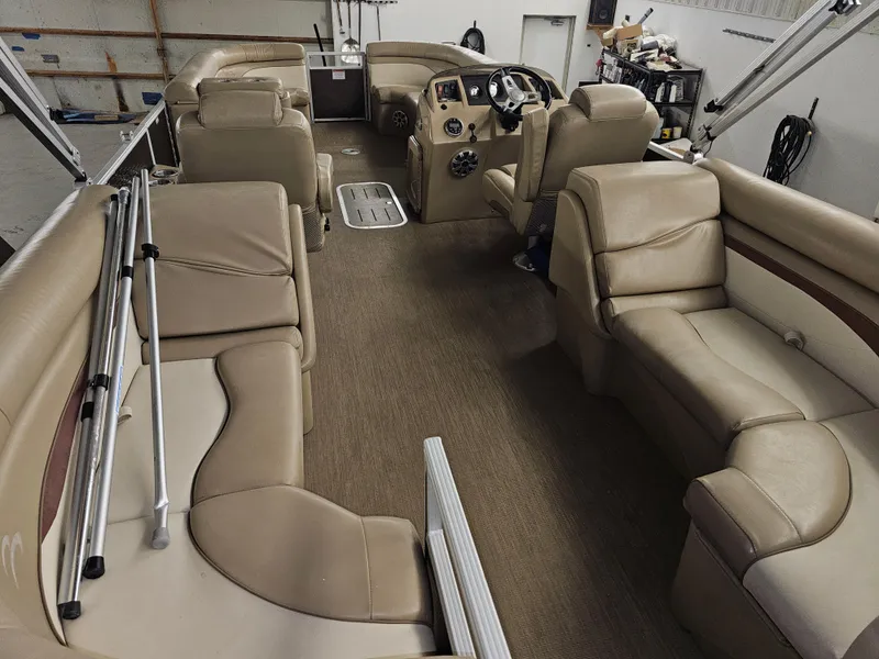 Slide: The Image of 2018 Bennington SX25 pontoon boat interior with beige seating and steering console. - 7