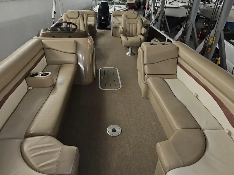 Slide: The Image of 2018 Bennington SX25 pontoon boat interior with beige seating and steering console. - 8