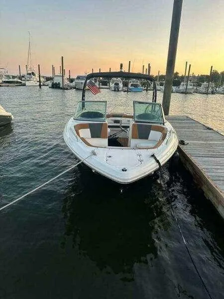 The Image of 2023 Chaparral 230 SSi boat docked at sunset in a marina. - 0