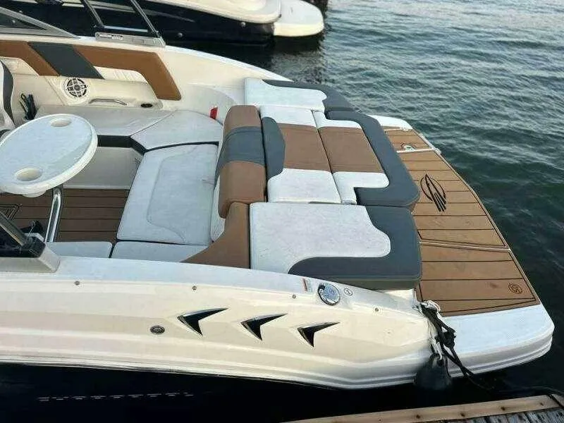 Slide: The Image of 2023 Chaparral 230 SSi boat with stylish seating and swim platform on the water. - 2