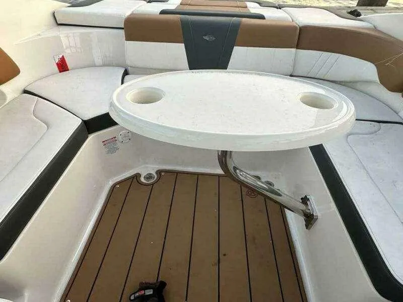 Slide: The Image of 2023 Chaparral 230 SSi boat interior with seating and a round table. - 4