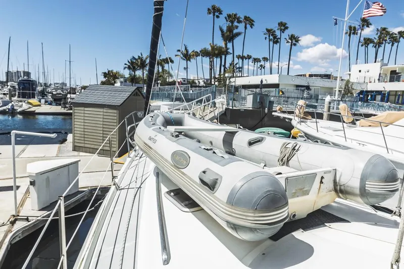 Slide: The Image of Sailboat docked at marina with inflatable dinghy, Hunter 456, 1997 model, palm trees in background. - 13