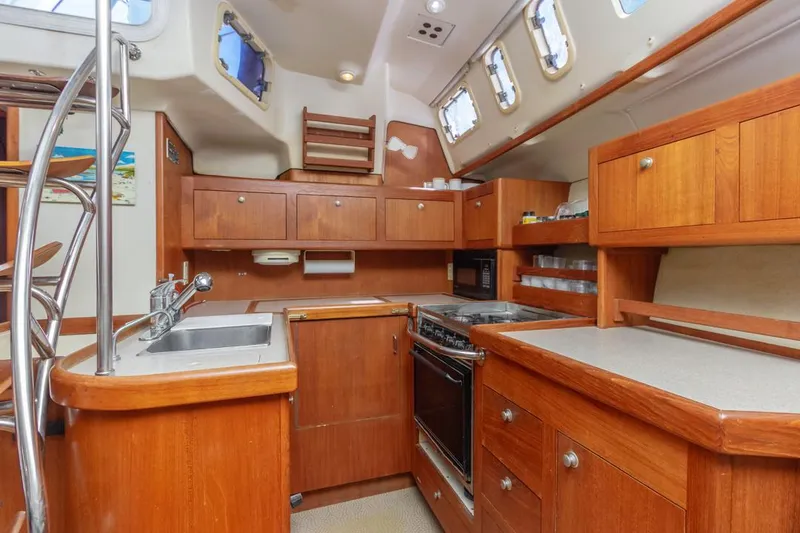 Slide: The Image of Interior of a 1997 Hunter 456 yacht kitchen with wooden cabinetry and modern appliances. - 2