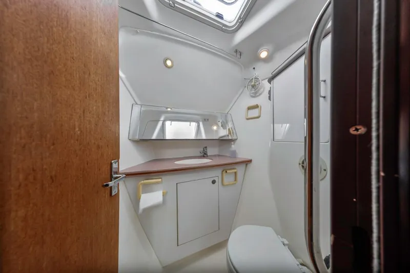 Slide: The Image of Bathroom interior of 1997 Hunter 456 yacht, featuring sink, mirror, and toilet. - 35