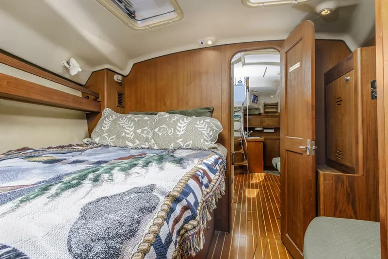Slide: The Image of Luxurious cabin interior of 1997 Hunter 456 yacht with cozy bed and wooden decor. - 36