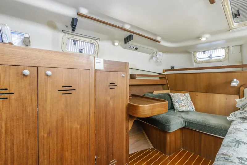 Slide: The Image of Interior of a 1997 Hunter 456 sailboat with wooden cabinetry and seating area. - 43