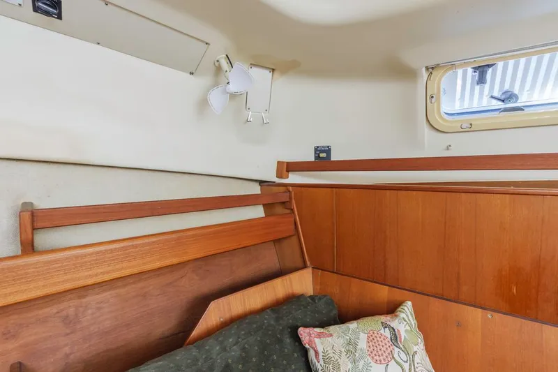 Slide: The Image of Cozy cabin interior of 1997 Hunter 456 sailboat with wooden paneling and a small window. - 44