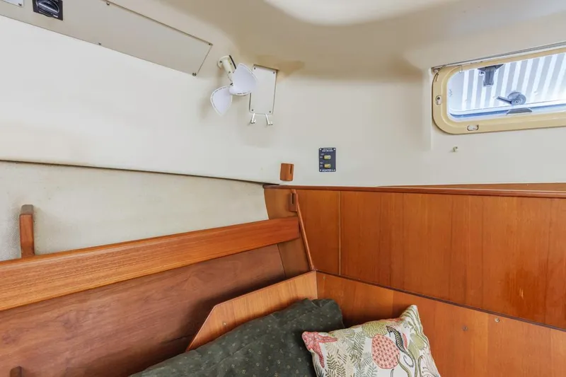 Slide: The Image of Interior cabin of a 1997 Hunter 456 yacht with wooden paneling and a small window. - 45