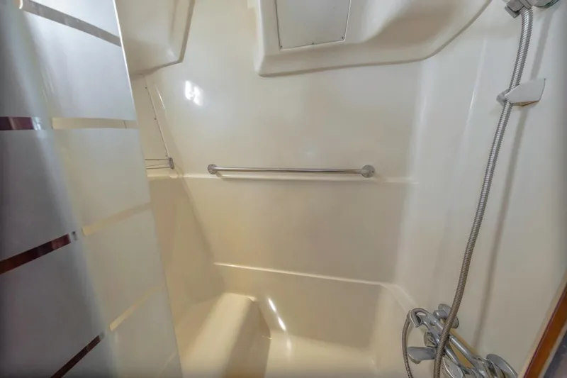 Slide: The Image of Compact shower area in a 1997 Hunter 456 boat, featuring a handheld showerhead. - 48