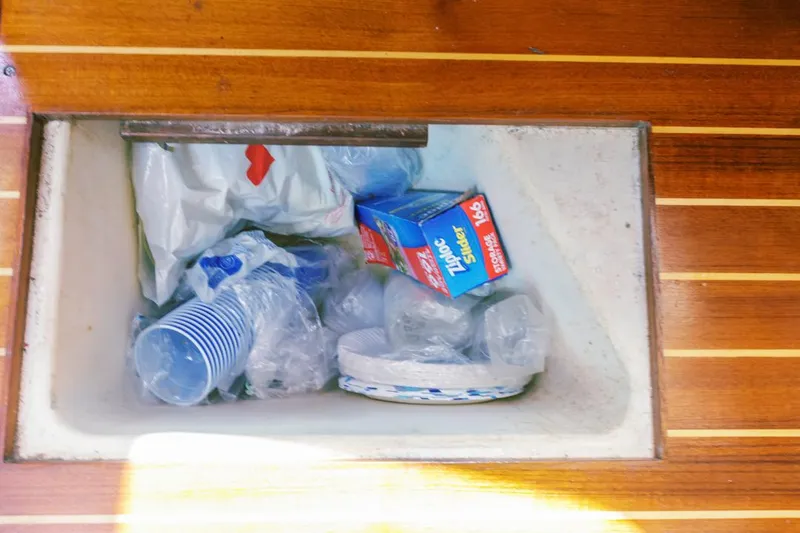 Slide: The Image of Storage compartment with plastic cups, plates, and Ziploc bags on a 1997 Hunter 456 boat. - 49