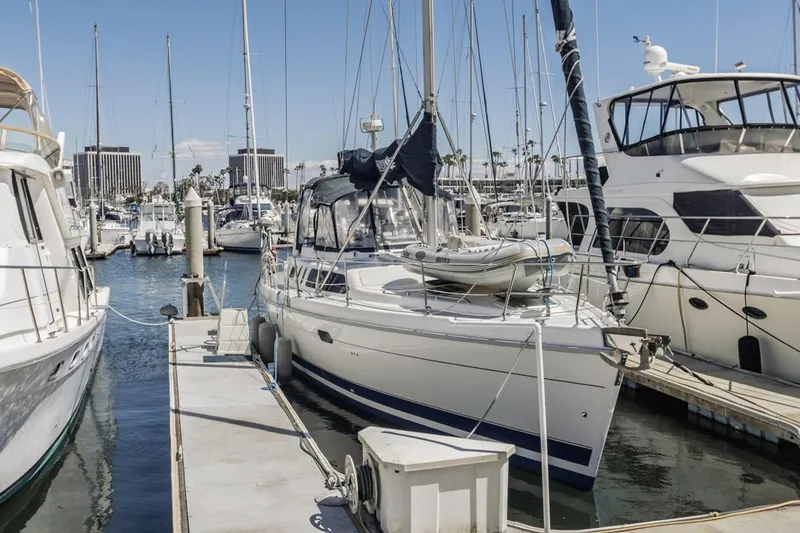 Slide: The Image of Hunter 456 sailboat from 1997 docked in a marina, surrounded by other boats. - 6
