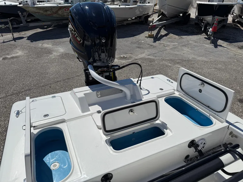 Slide: The Image of 2025 Tidewater 25 TPC Raptor boat with open storage compartments and outboard motor. - 4