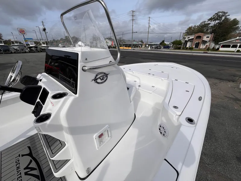 Slide: The Image of 2025 Tidewater 2110 Bay Max boat, white console, cup holders, and seating, parked outdoors. - 9