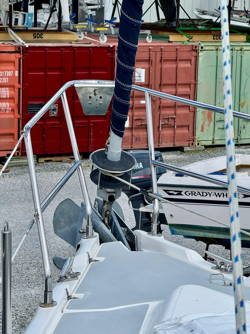 Slide: The Image of 2003 Hunter Passage 420 sailboat bow with anchor, docked near shipping containers. - 10