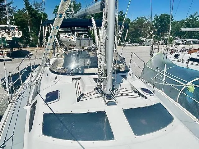 Slide: The Image of 2003 Hunter Passage 420 sailboat docked, showcasing deck and rigging under clear blue sky. - 14