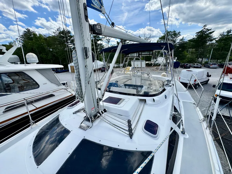 Slide: The Image of 2003 Hunter Passage 420 sailboat docked, showcasing deck and mast under a partly cloudy sky. - 15